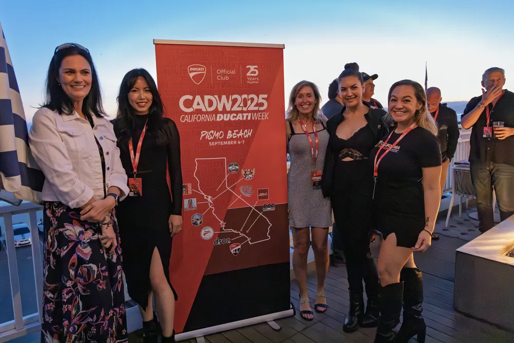 A group of attendees at the CADW 2025 banner during the welcome reception