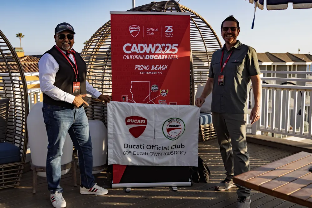Two members holding the Ducati Official Club San Diego banner at the reception