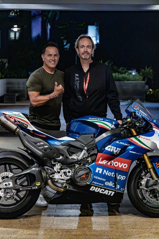 Two attendees beside the Ducati Lenovo MotoGP Panigale V4 on display at the gala