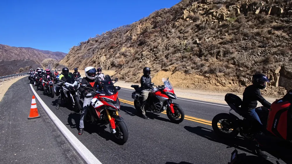 A line of Ducatis riding single file through a canyon road on the CADW 2025 group ride