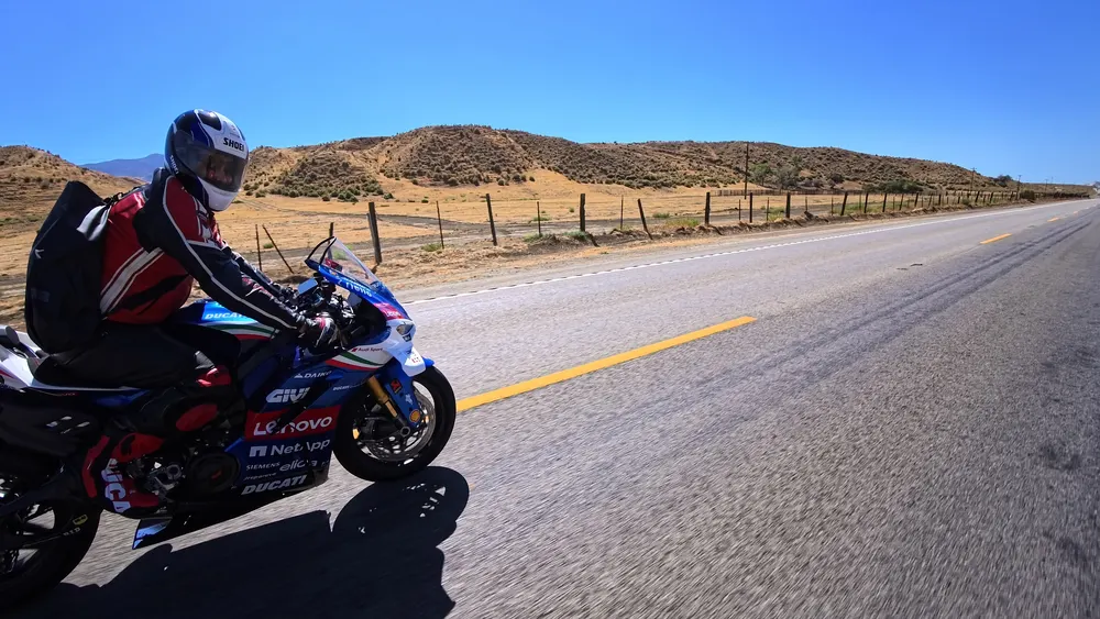 A rider on a Ducati Panigale on an empty two-lane road inland from Pismo Beach