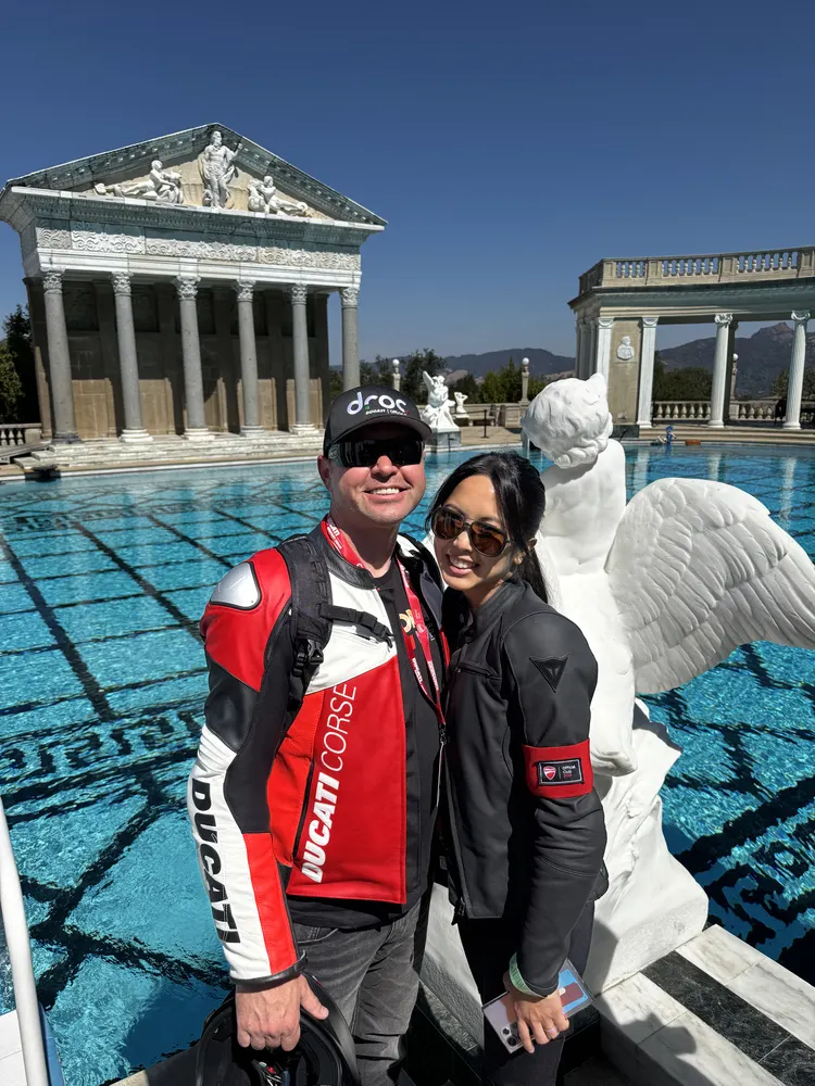 Two CADW 2025 attendees in Ducati jackets at the Neptune Pool at Hearst Castle