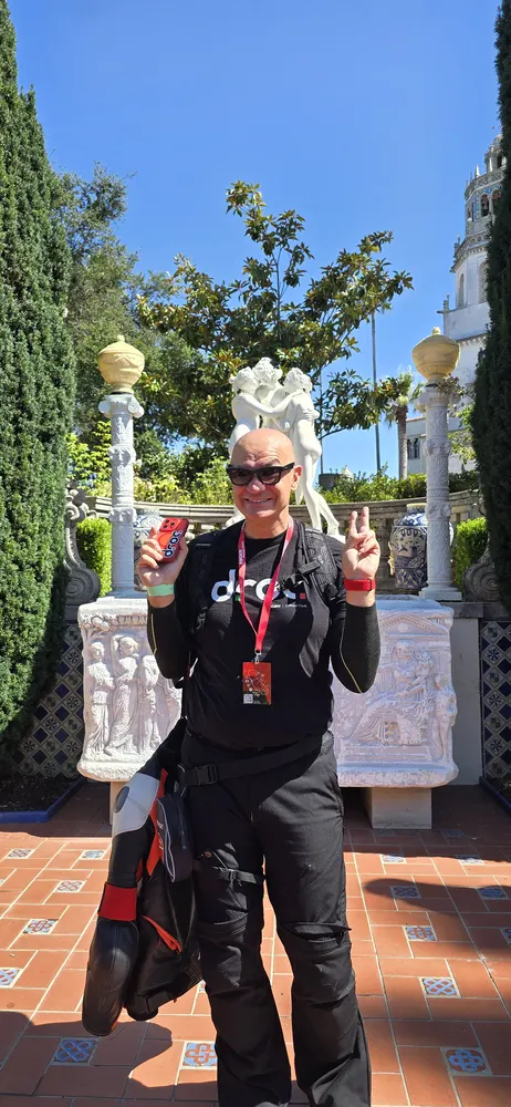 An attendee posing beside the marble statuary in the Hearst Castle gardens