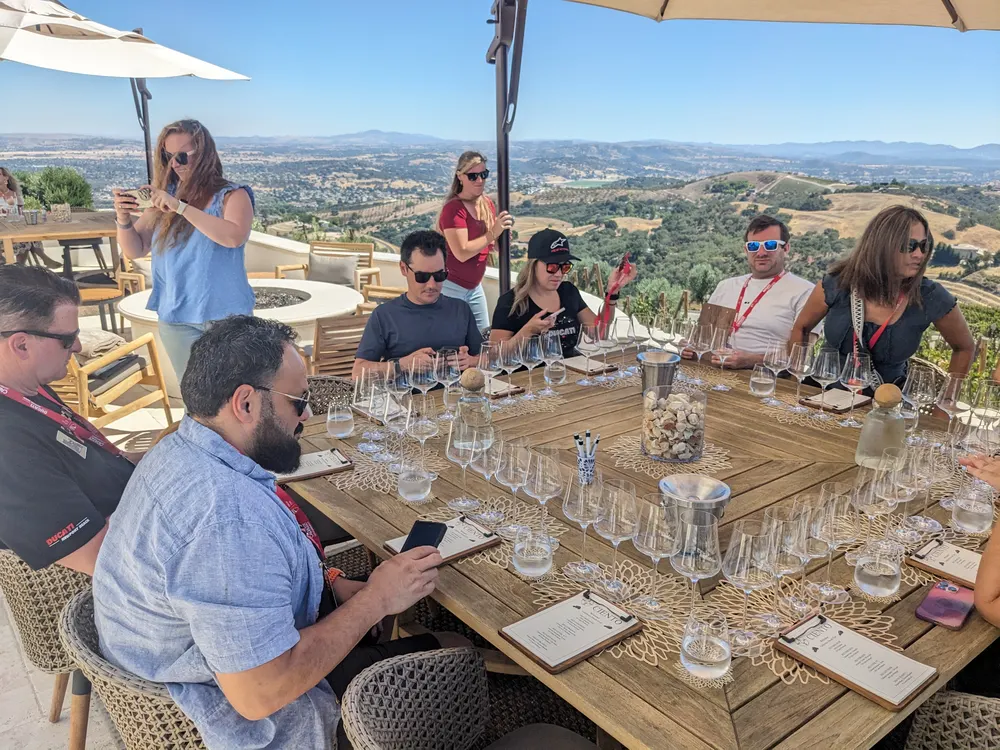 The winery bus tour group at a tasting table overlooking the Paso Robles hills