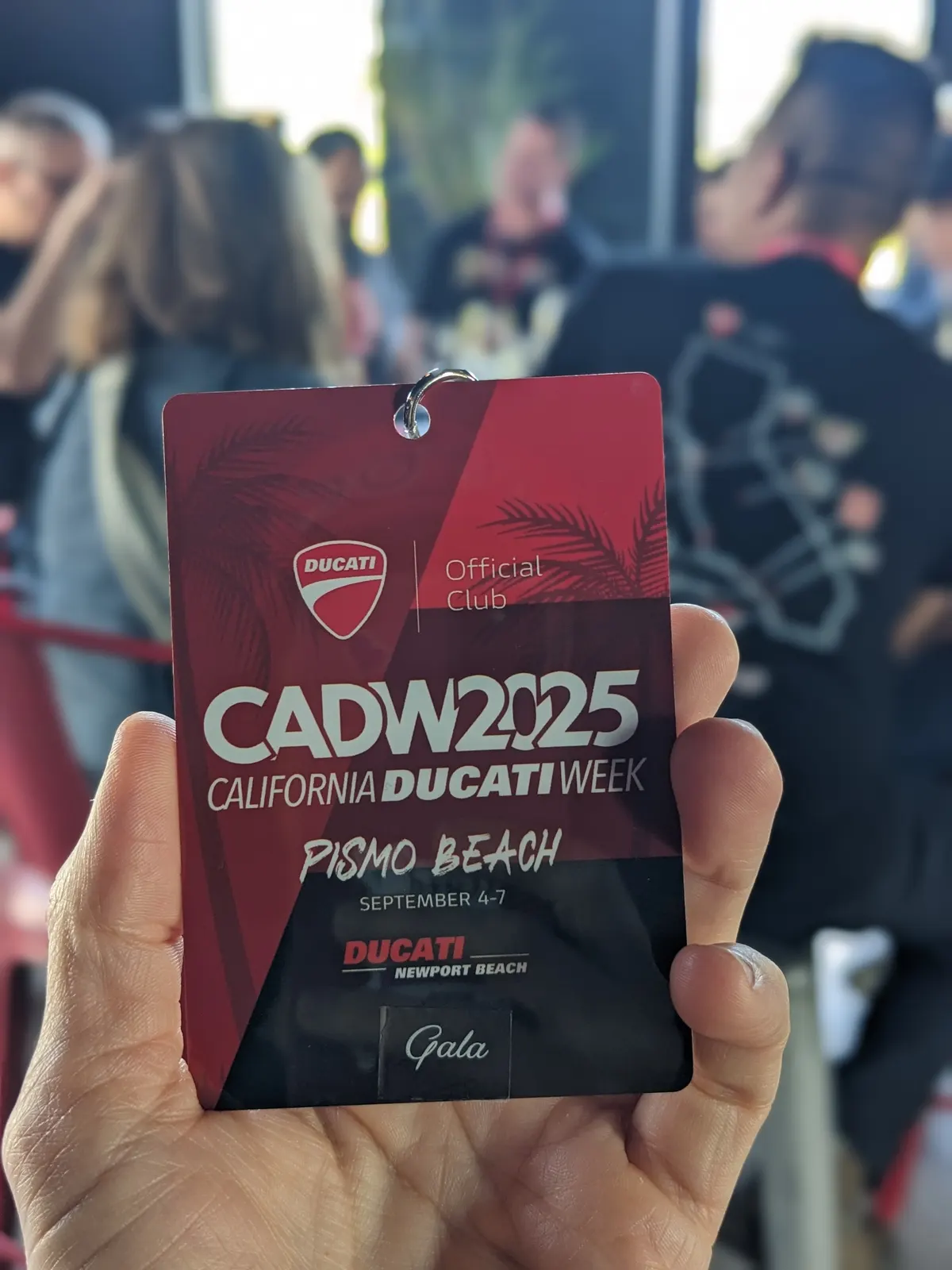 A CADW 2025 Paso Robles wine tour credential held up at the tasting
