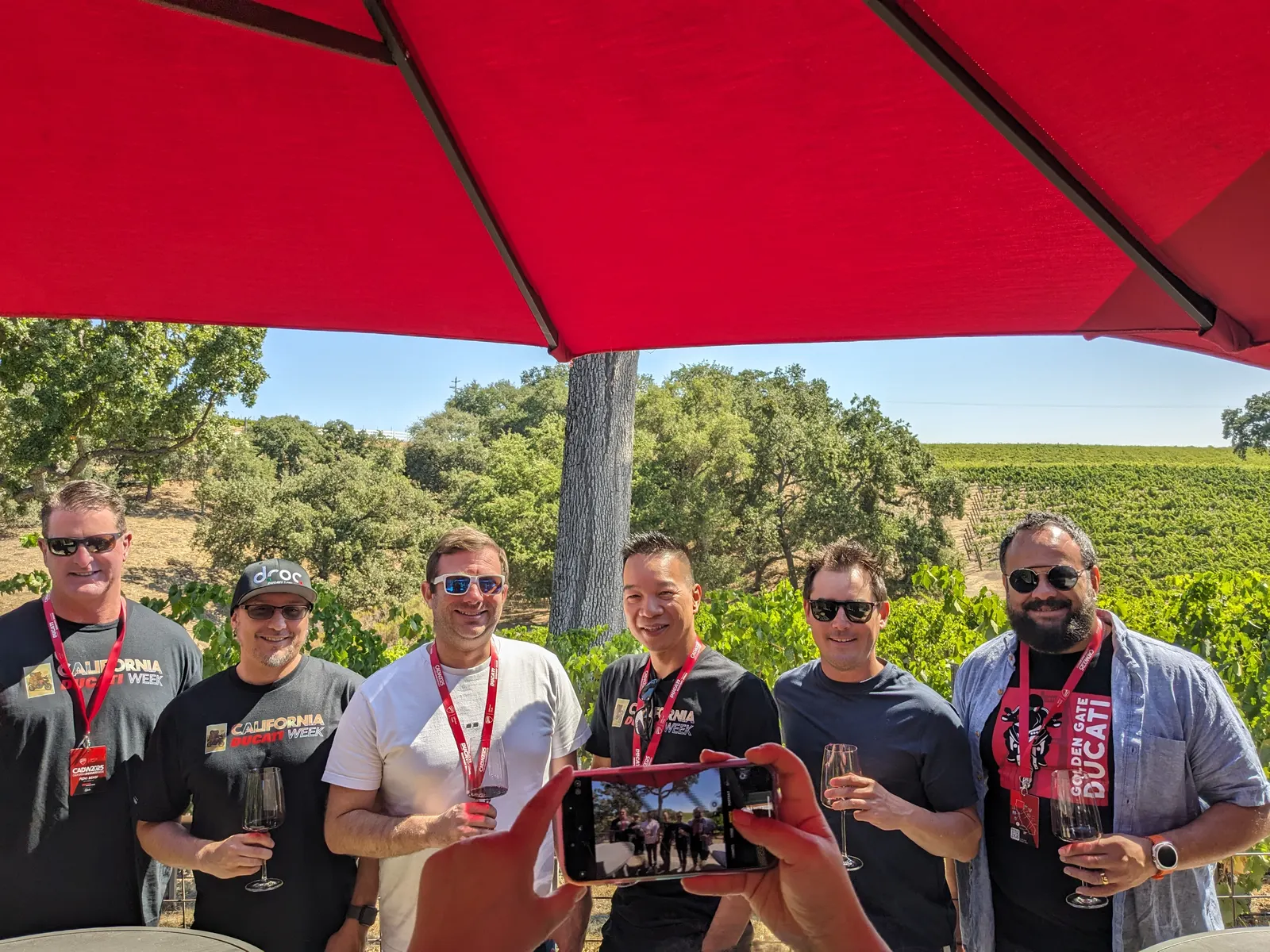 Wine tour friends posing together with the Paso Robles vineyard behind them