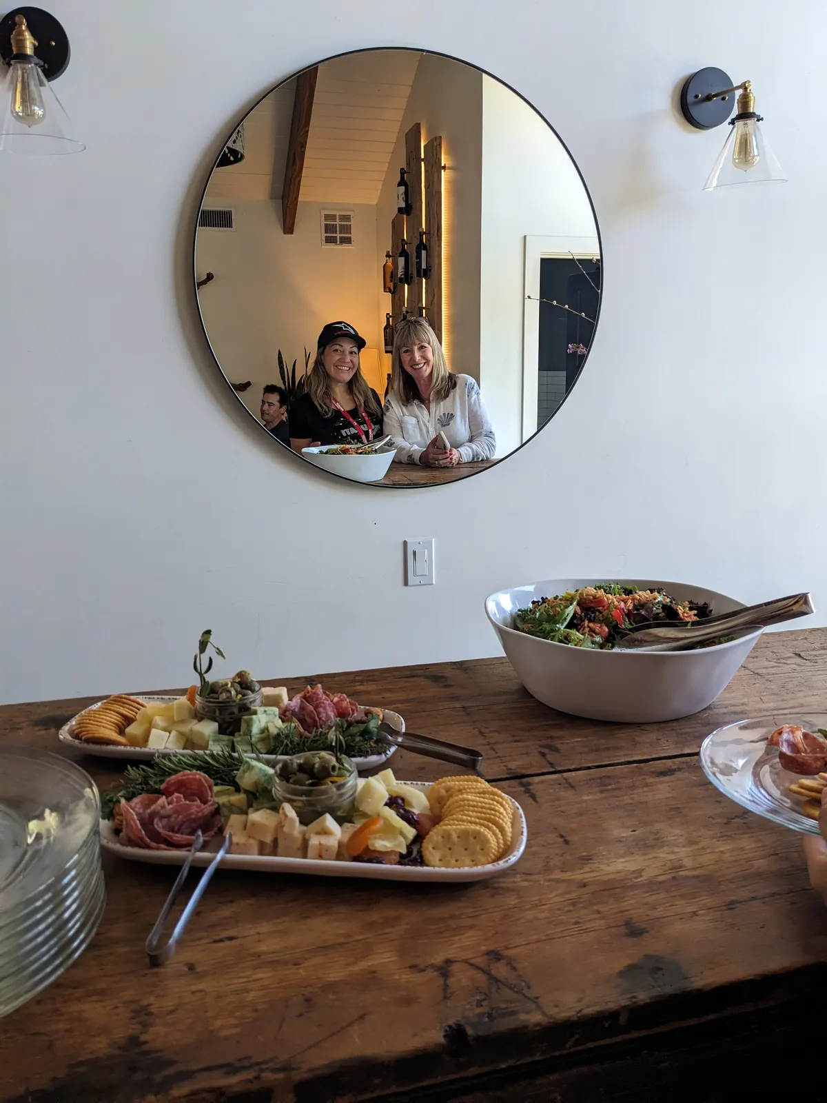 Two winery hosts presenting a board of local food to the group