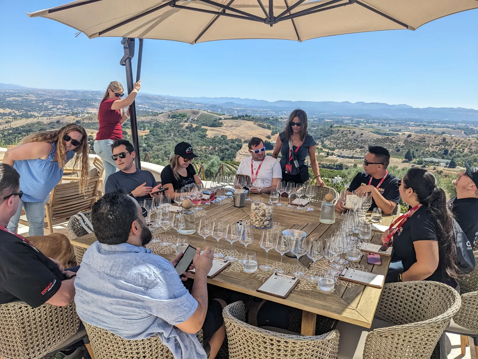 Participants sharing an outdoor tasting table above the Paso Robles hills