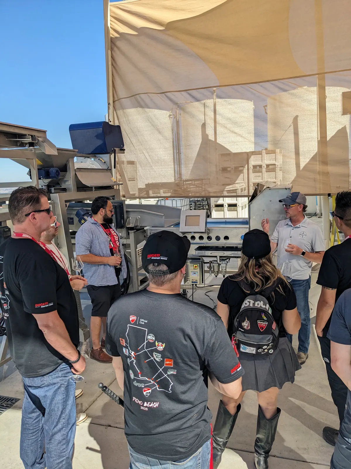 The wine tour group gathered beneath a shaded winery tent