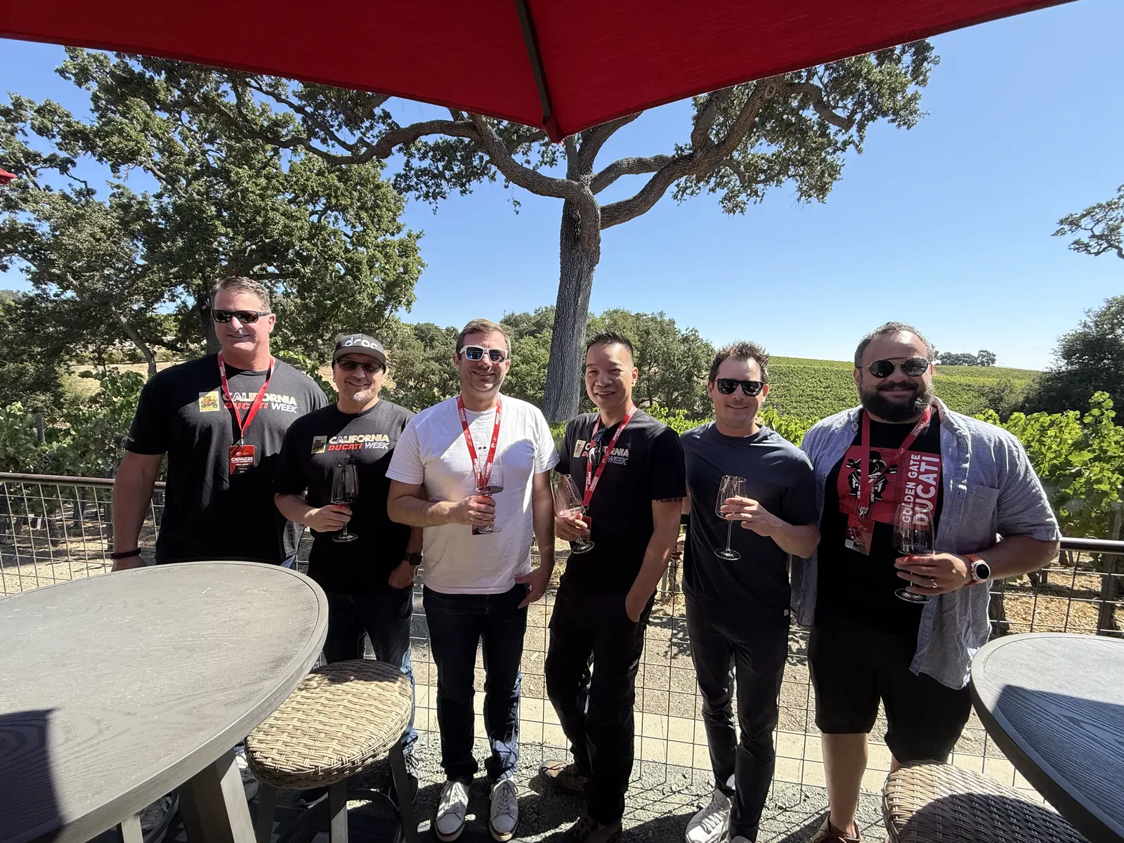 Six wine tour participants smiling together beside the tasting patio