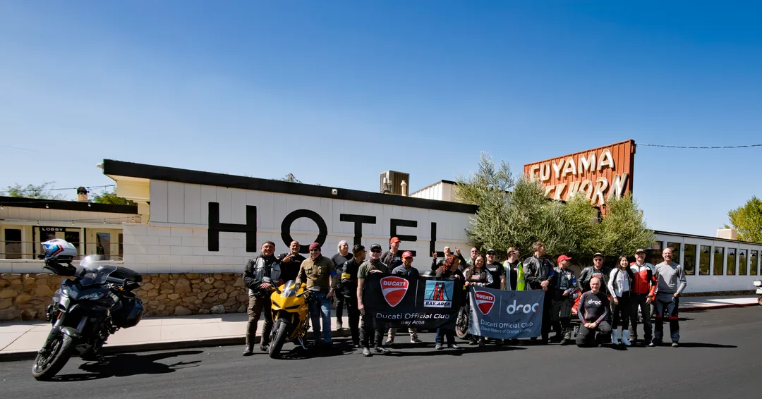 The Friday Ride B group and motorcycles gathered outside a roadside hotel.