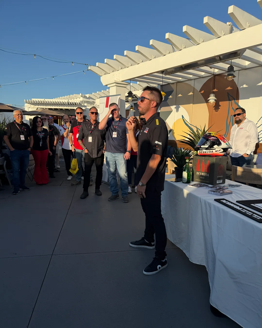 The Friday meet and greet on the terrace, with attendees gathered around the speaker.