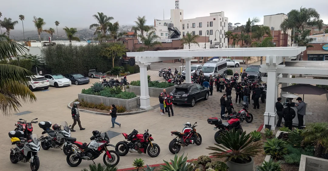 Motorcycles and riders gathering near the palm-lined Pismo Beach promenade.