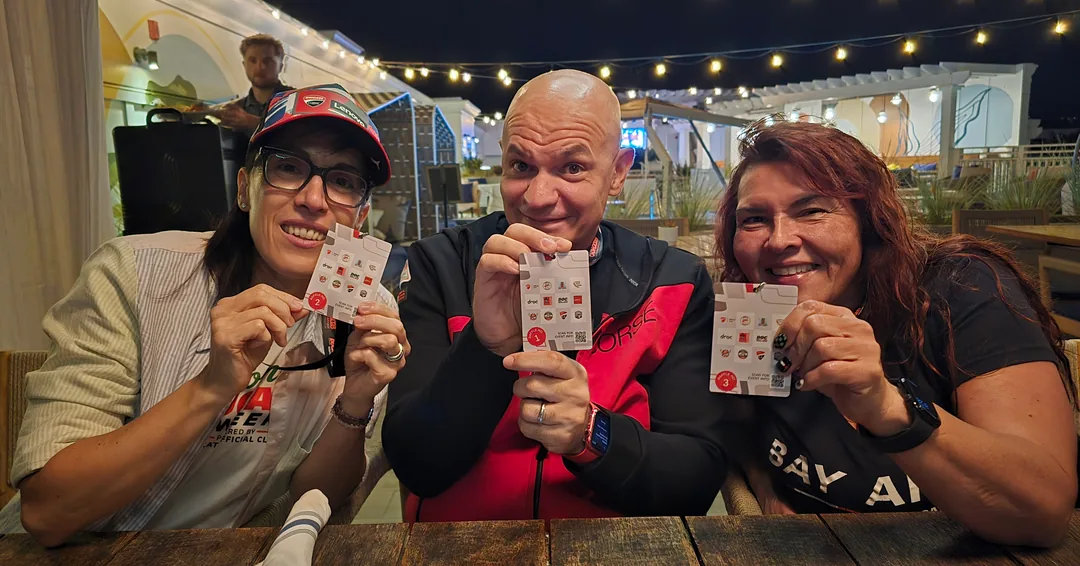 Three friends holding playing cards at the Thursday welcome reception.