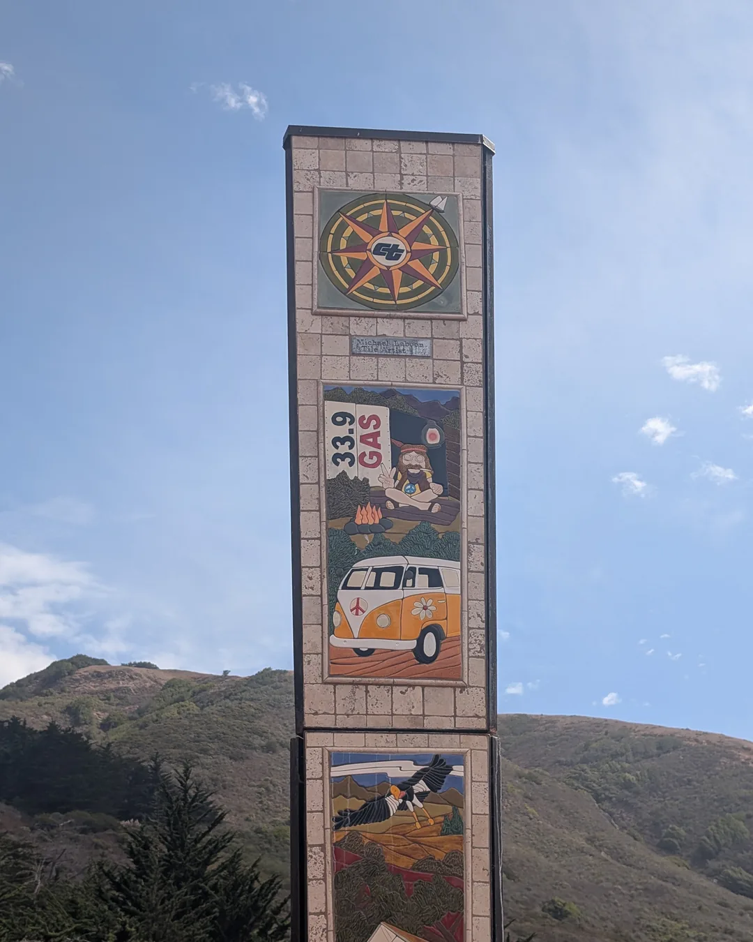 A tall roadside sign against blue sky and California hills on the Friday ride.