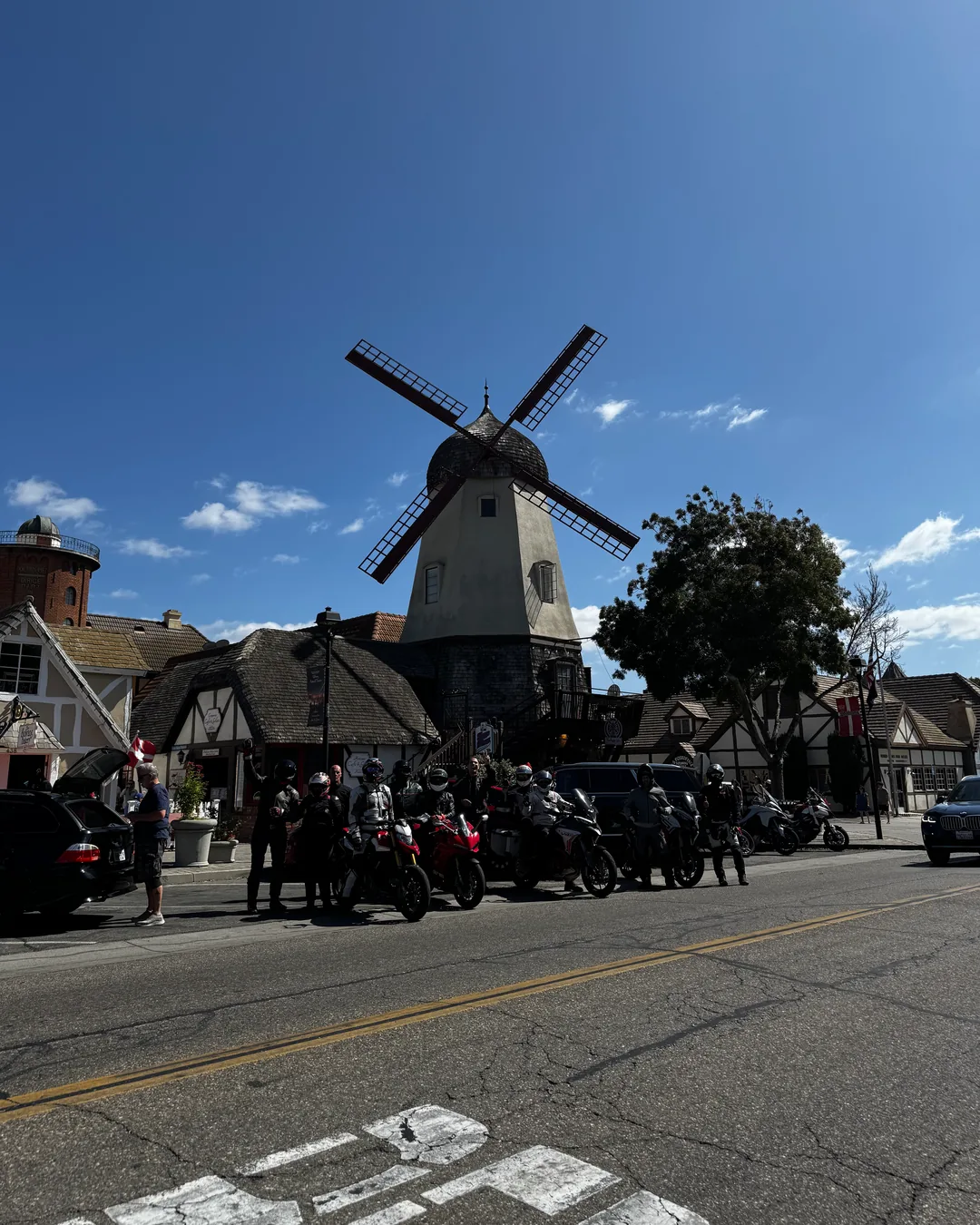 Motorcycles and riders below a windmill on the Southern California ride to Pismo Beach.