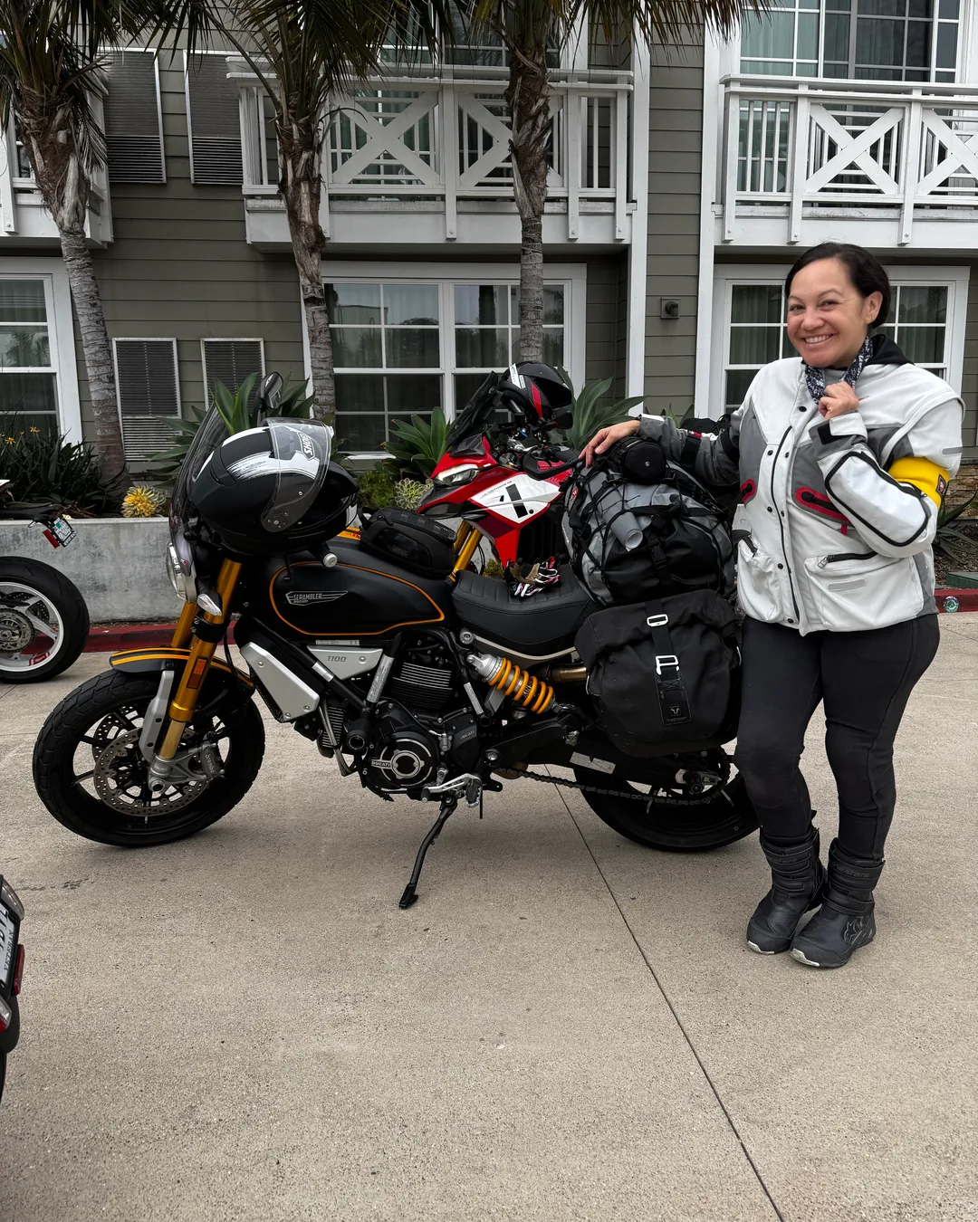 A rider standing beside a luggage-loaded Ducati before the Sunday ride home.
