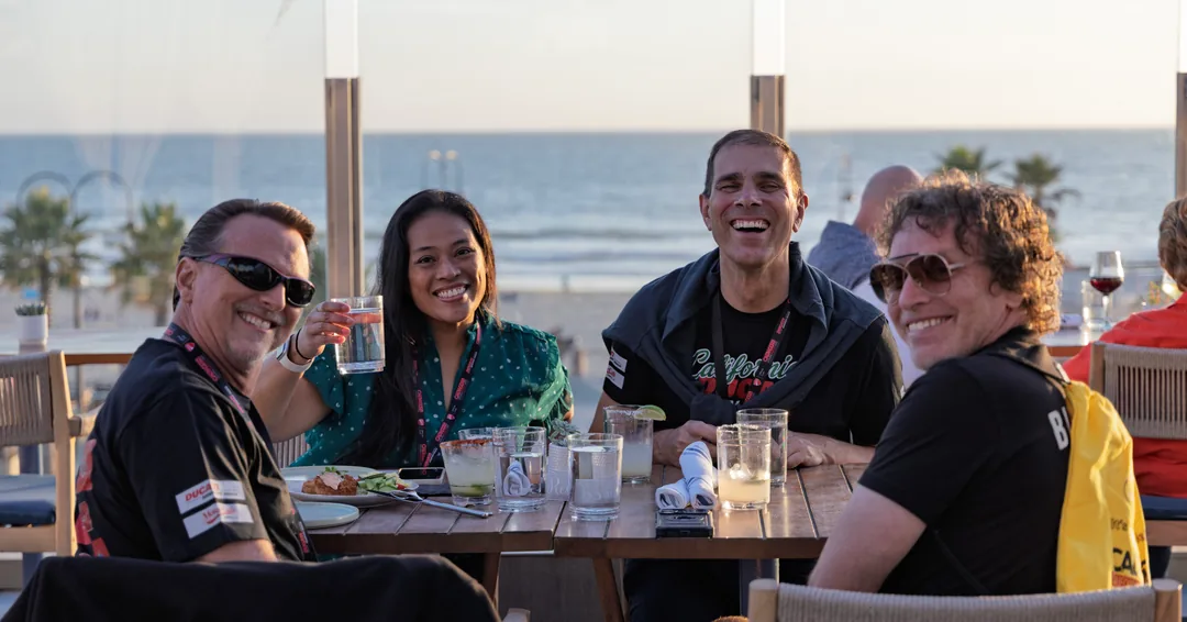 Four friends sharing a table on the terrace during the Thursday reception.
