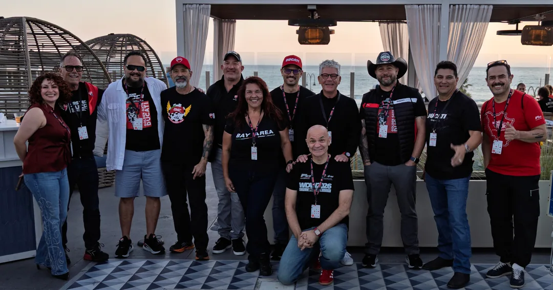 Ducati club friends posing together on the terrace at the Thursday reception.