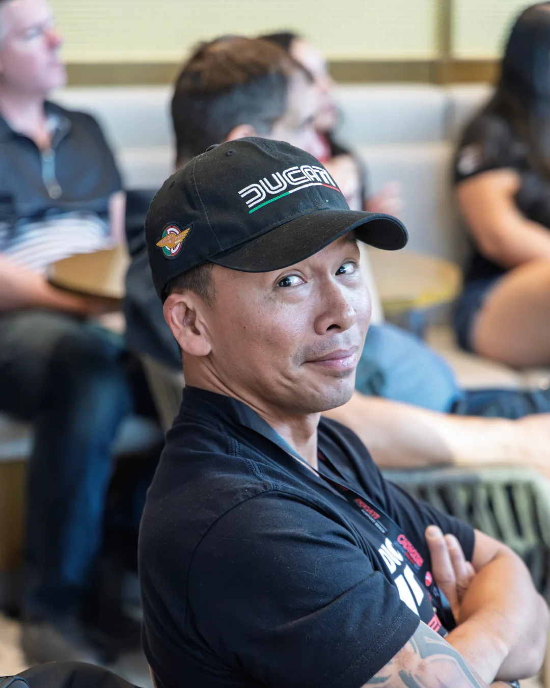 A workshop attendee in a Ducati cap turning toward the camera.