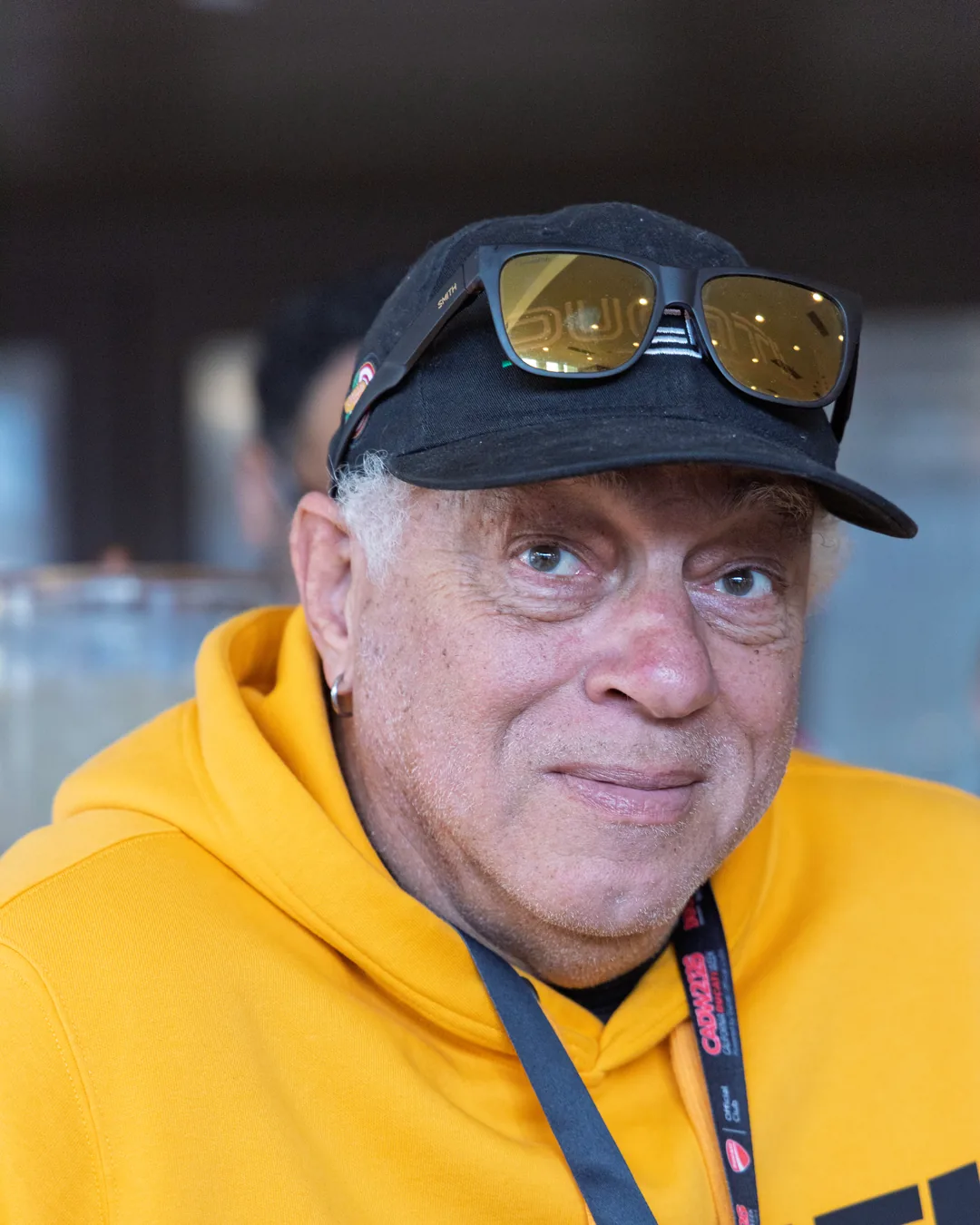 A smiling attendee in a yellow Ducati hoodie at the Saturday workshop.