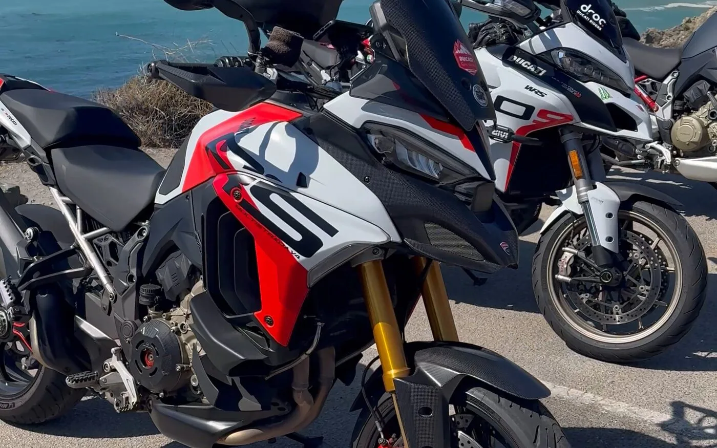 Two Ducati Multistrada adventure bikes parked at a Pacific Coast overlook